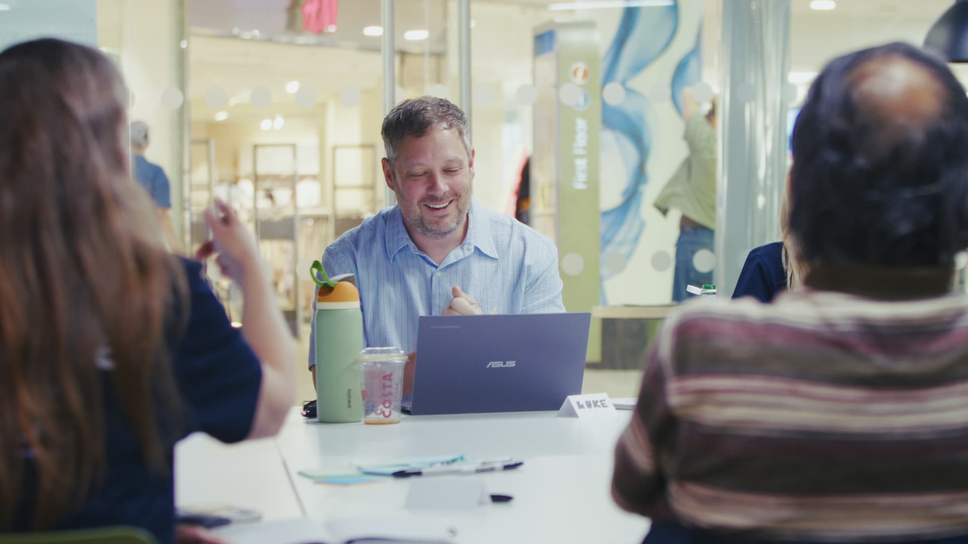 A participant smiling while working on a laptop at an AI Lab pop-up